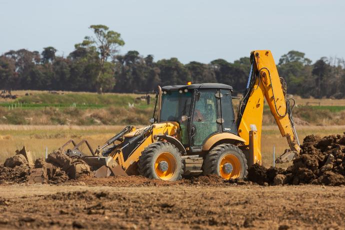 a bulldozer digging dirt in a field
